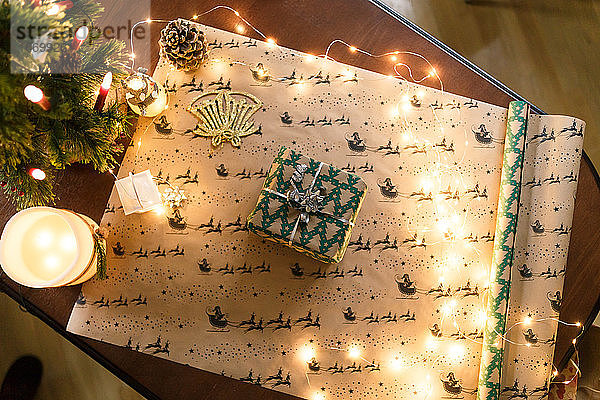 Weihnachtsgeschenk sorgfältig in buntem Papier verpackt auf einem Hintergrund