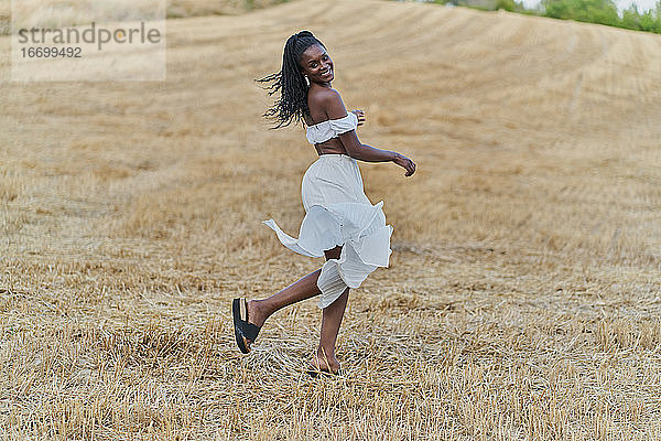 Fotosession einer schönen und glücklichen schwarzen Frau in einem Weizenfeld