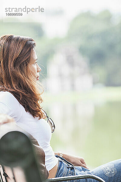 schöne Frau entspannt am Hoan Kiem See in Hanoi / Vietnam