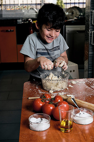Kind bereitet Pizzateig für zu Hause zu