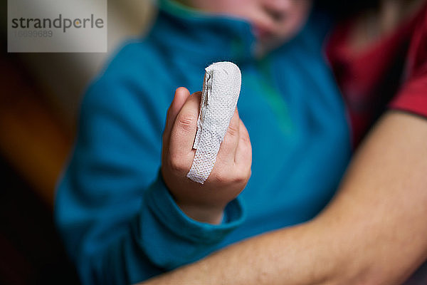 Ein Kind mit bandagiertem Finger