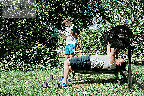 zwei Männer trainieren gemeinsam in einem Fitnessstudio im Garten