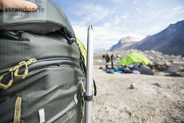 Detail eines Eispickels eines Bergsteigers  der auf einen Rucksack am Campingplatz geschnallt ist.