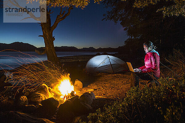 Frau arbeitet am Laptop in einem Camp am Nahuel Huapi See in Patagonien