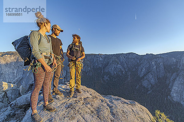 Drei Wanderer auf dem Gipfel des El Capitan im Yosemite Valley bei Sonnenuntergang