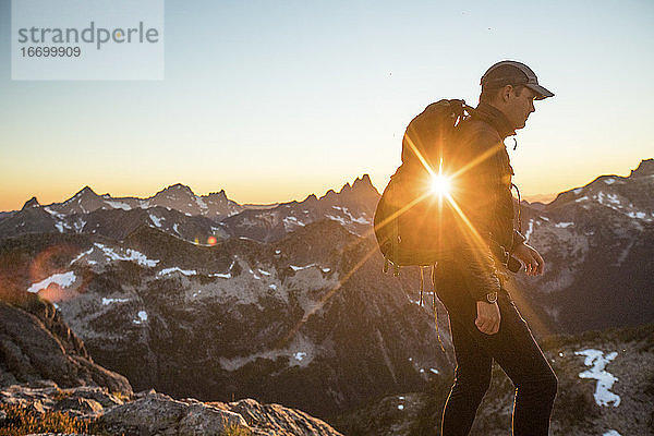 Seitenansicht eines Rucksacktouristen beim Wandern in den Bergen.