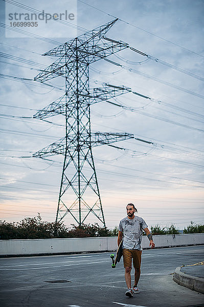 Ein Junge fährt mit dem Skateboard in der Hand