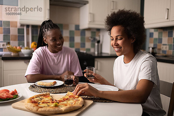 Ethnische Frau genießt Pizza mit Freund