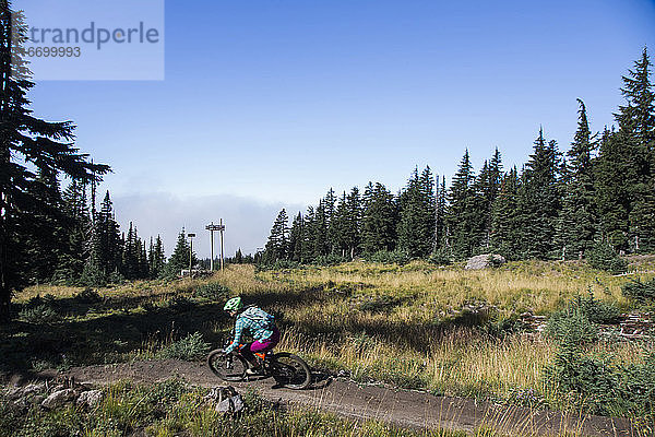 Eine junge Frau fährt an einem sonnigen Tag am Mt. Hood  Oregon  mit dem Fahrrad.
