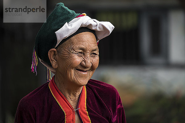 Porträt einer lächelnden älteren Frau vom Stamm der Palong mit Kopfbedeckung  in der Nähe von Hsipaw  Myanmar