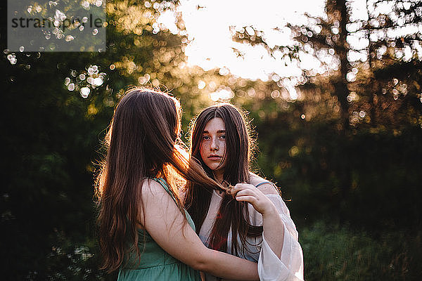 Junges lesbisches Paar  das im Sommer im Wald steht