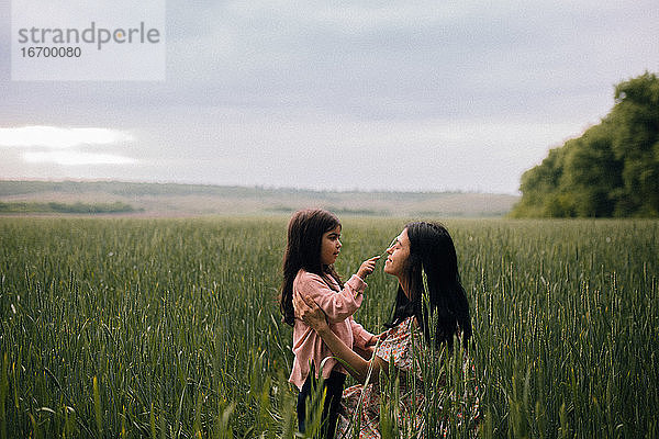 Lächelnde Mutter und Tochter  die sich auf einem Feld unterhalten