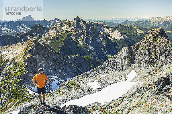 Trailrunner blickt vom Gipfel eines Berges aus auf die Aussicht.