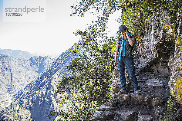 Frau schaut vom Inkapfad in der Nähe von Machu Picchu hinunter