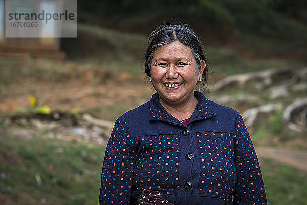 Lächelnde reife Frau vom Stamm der Palong  die im Freien steht  in der Nähe von Hsipaw  Myanmar