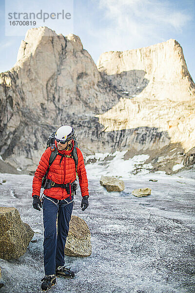 Bergsteiger  der unterhalb eines Gipfels unterwegs ist.