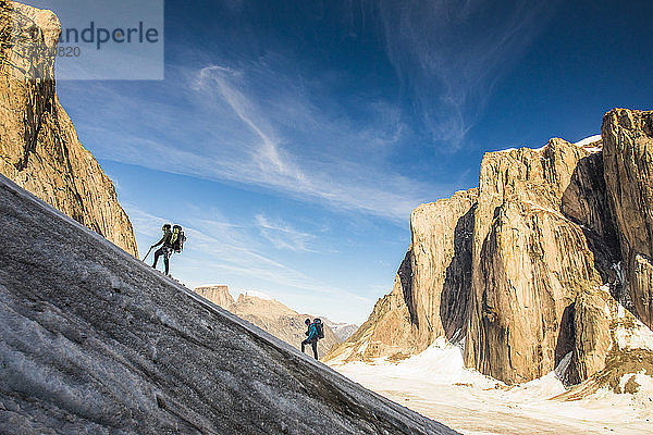 Rucksacktouristen wandern auf einem Gletscher und besteigen den Berg Asgard  Baffin Island.