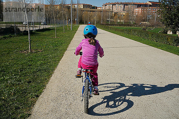 Mädchen auf einem Fahrrad von hinten gesehen