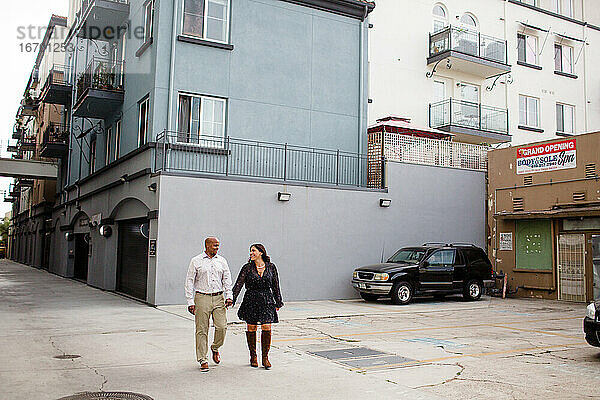 Spätes vierzigjähriges Paar  das sich in einer Gasse in San Diego an den Händen hält
