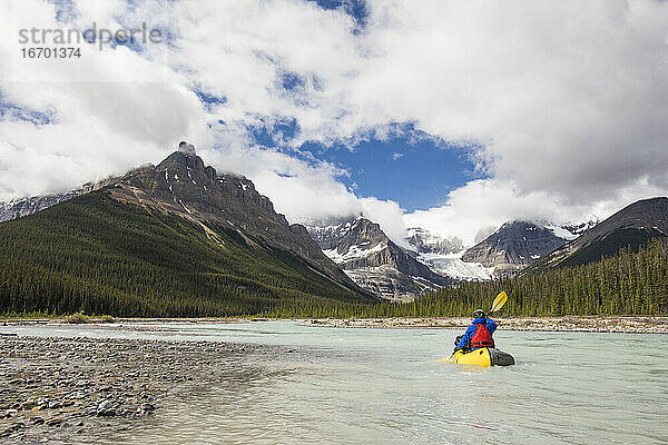 Mann paddelt auf einem malerischen Fluss  Rocky Mountains  Alberta  Kanada.