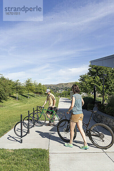 Zwei Freunde parken ihre Fahrräder an einem Ständer in einem Park in The Dalles  Oregon