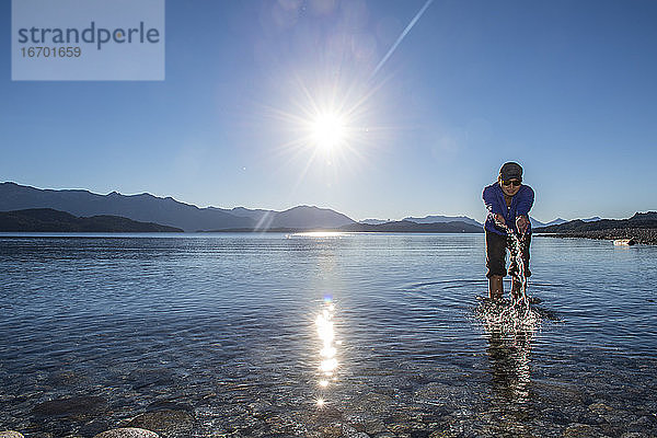 Frau probiert das Wasser am Nahuel Huapi See in Patagonien aus