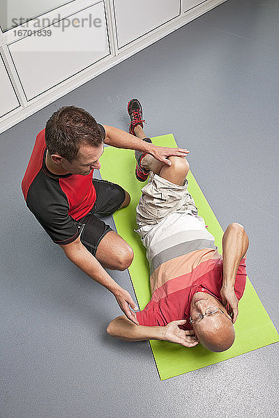 Personal Trainer hilft Kunden im Fitnessstudio