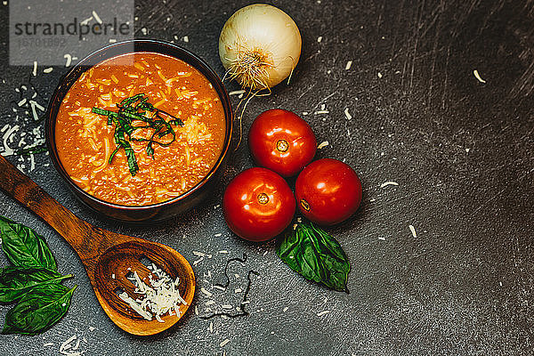 Rustikale Tomaten-Basilikum-Suppe Zwiebel-Tomaten-Holzlöffel-Käse geschmolzen warm