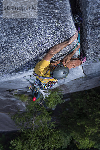 Mann lag mit dem Rücken zu einer breiten Spalte hoch über dem Boden auf Granit Squamish