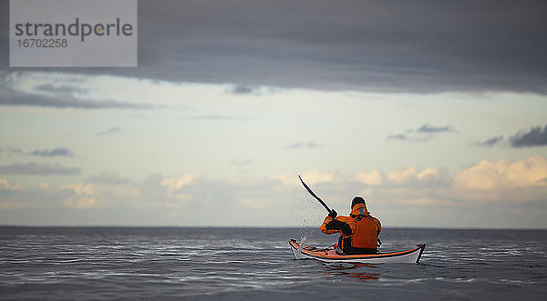 Reifer Mann steuert sein Seekajak durch die ruhigen Gewässer um Reykjavik