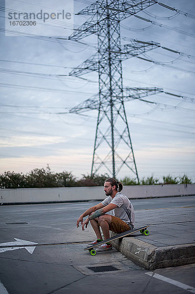 Junge posiert mit Skateboard in der Hand