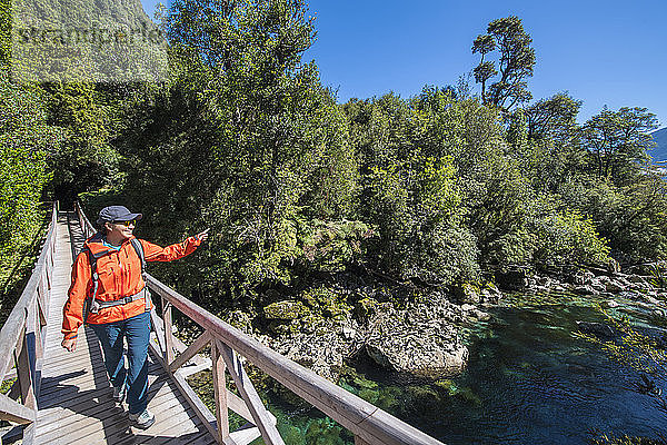 Frau überquert Holzbrücke bei Caleta Gonzalo in Chile