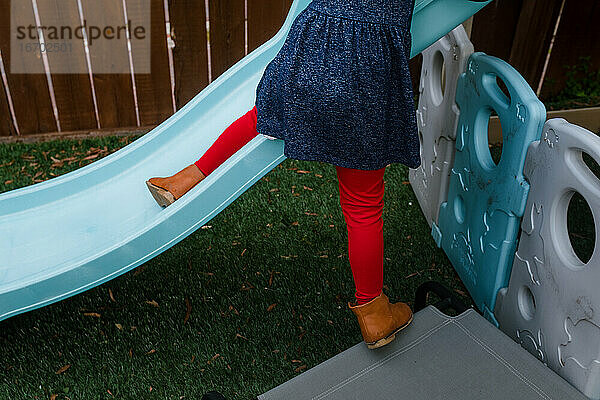 Kleines Mädchen klettert draußen auf der Rutsche