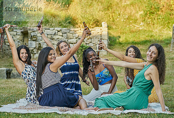 Gruppe von Freundinnen trinken Bier in einem Park an einem Sommertag