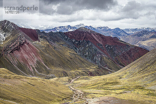 Panoramablick auf ein Tal inmitten hoher Andenberge auf dem Rainbow Mountain Trail  Pitumarca  Peru