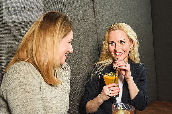 Erwachsene Frau ruht sich mit einem Freund in einer Bar aus