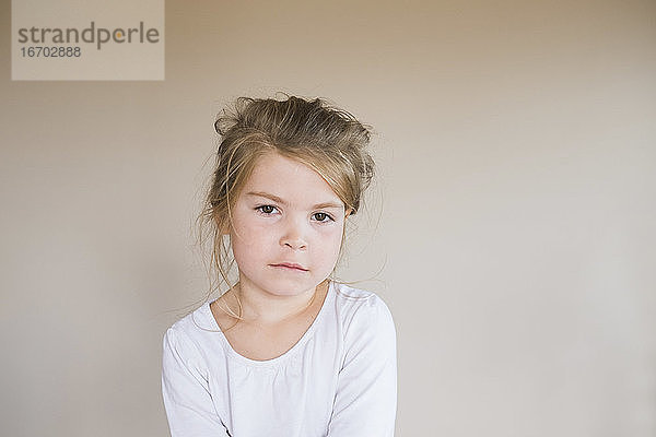 Porträt eines jungen Mädchens  das mit ernster Miene in die Kamera schaut