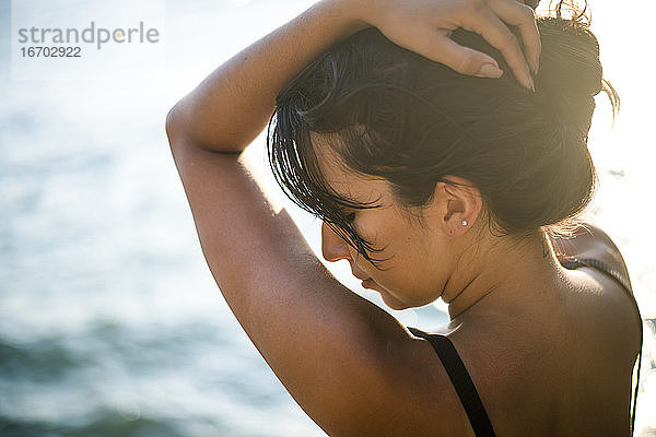 Junge Latina Frau entspannt am Meer zur goldenen Stunde im Sommer