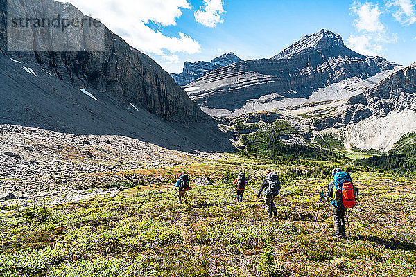 Eine Gruppe von Wanderern steigt in ein abgelegenes Alpental bei Banff hinab