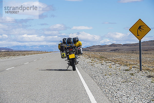 Abenteuermotorrad neben einem Windwarnschild in Argentinien geparkt