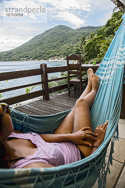 Frau entspannt in Hängematte auf der tropischen Insel Ilha Grande