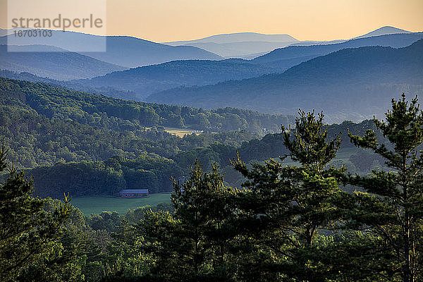 Sonnenuntergang über Feldern und einer Scheune in der Nähe von Woodstock  Vermont.