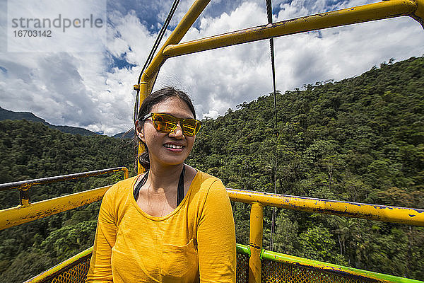 Frau bei einer Seilbahnfahrt am Wasserfall in Mindo  Ecuador