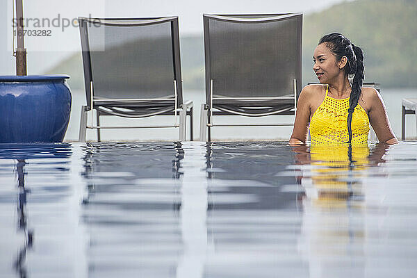 schöne Frau genießt eine entspannende Zeit im Pool eines Luxusresorts