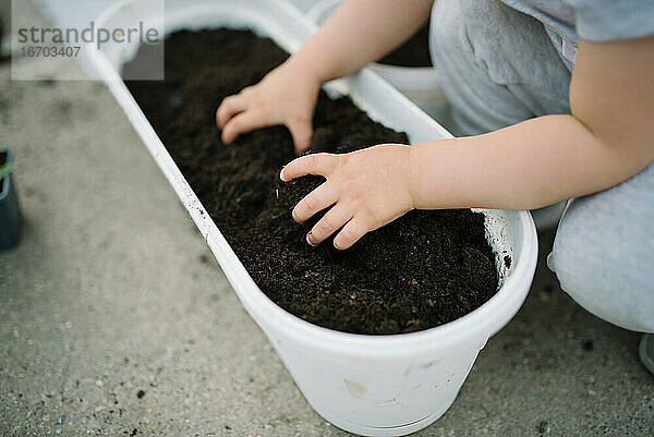 Ein kleines Mädchen hat Spaß im Garten und hält ein Gartengrundstück