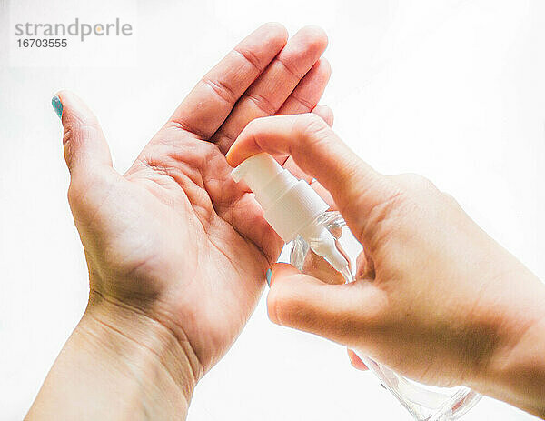 weibliche Hände beim Auftragen von Handdesinfektionsgel
