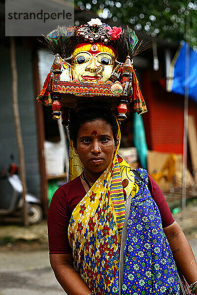 Indische Frau trägt einen Altar auf dem Kopf  um ihn in den Tempel zu bringen.