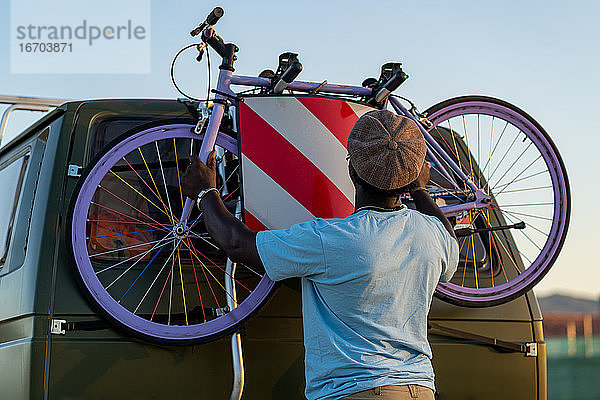 Afroamerikanischer Mann mit einem altmodischen Fahrrad in seinem Lieferwagen