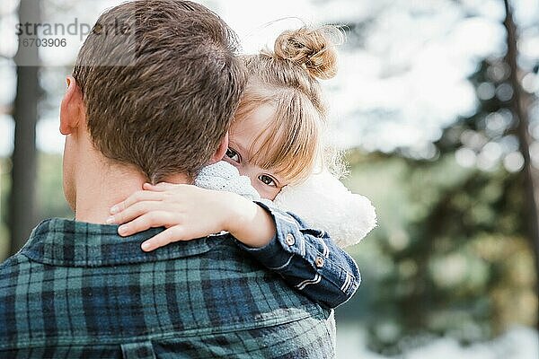 kleines Mädchen  das von ihrem Vater getragen wird  der hinter ihr steht und gemütlich aussieht