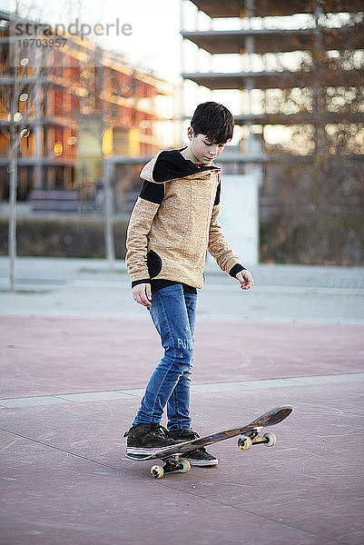 Männlicher Skateboarder fährt und übt Skateboard in der Stadt im Freien